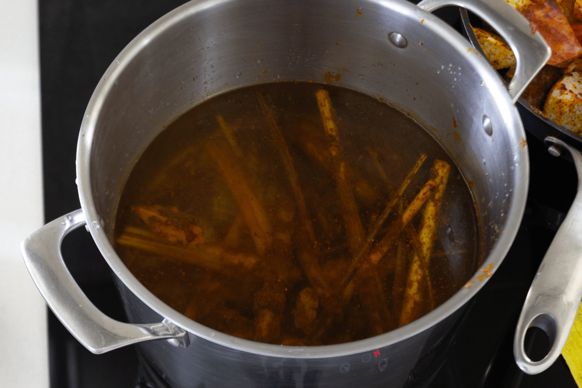 Lemongrass and curry powder in a pot of water.