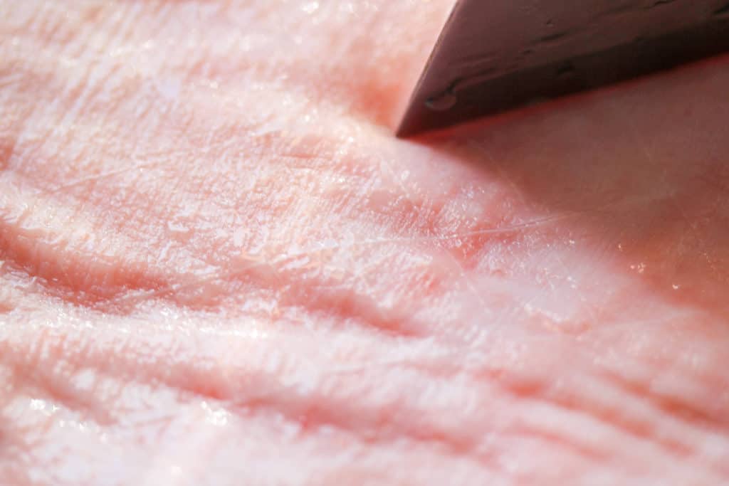 knife scoring pork belly skin